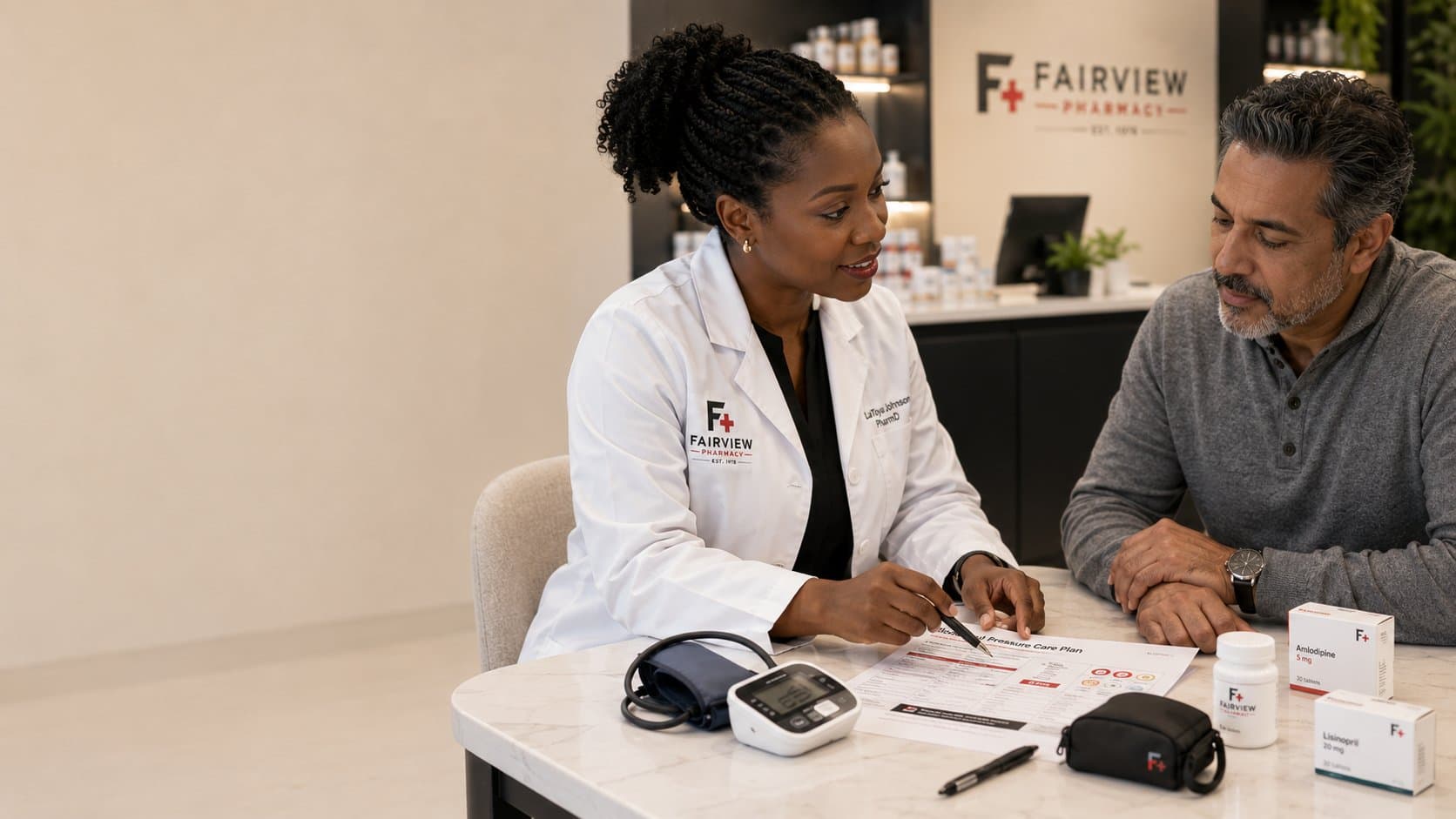 Fairview Pharmacist LaToya Johnson reviewing a blood pressure care plan with a patient at the counter, blood pressure cuff and Fairview branded Amlodipine and Lisinopril packs on the table