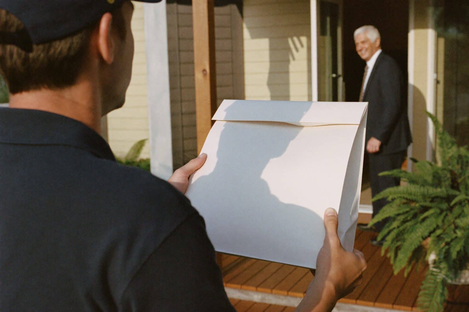 A Fairview Pharmacy delivery being handed to a smiling patient at her front door